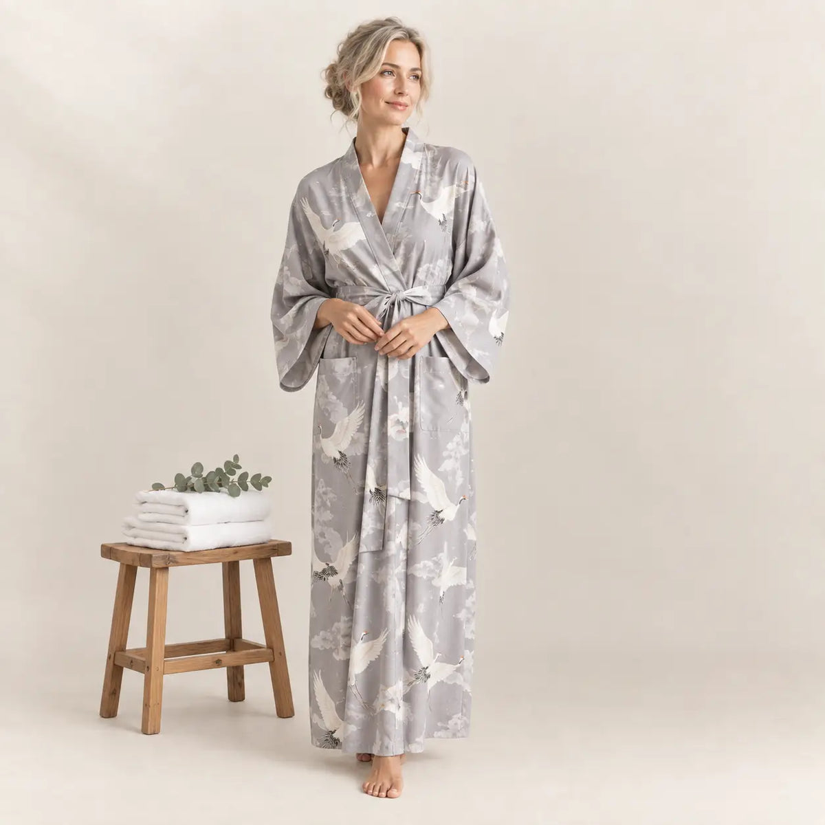 A flowing gray silk kimono bathrobe for women with wide sleeves and a delicate white crane pattern. Image