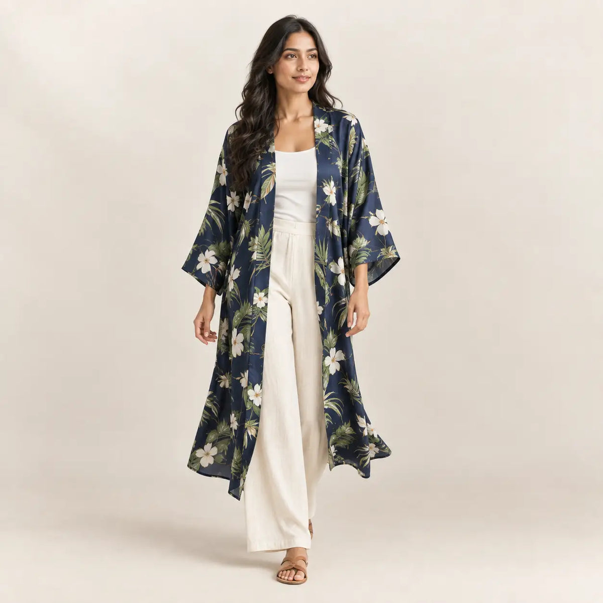 A navy blue floral kimono cardigan with white blossoms green leaves featuring a loose flowing design Image