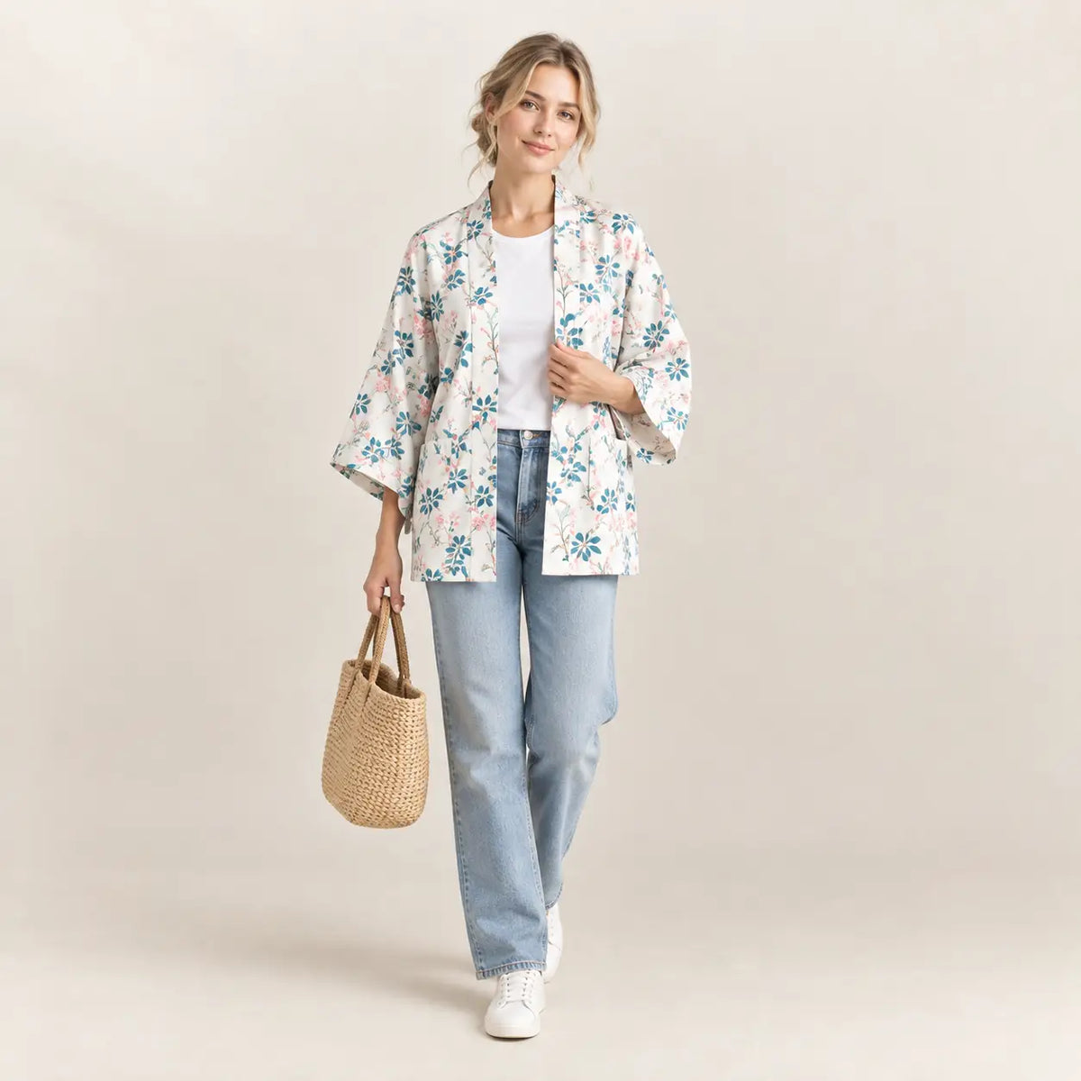 A woman wears a light-colored floral print short kimono with soft flowing sleeves and an open front. Image