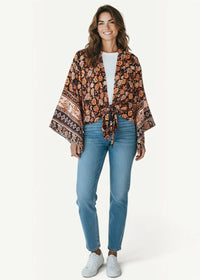 Beach kimono women flowing earth-toned floral fabric with intricate border patterns and a tied waist for casual wear
