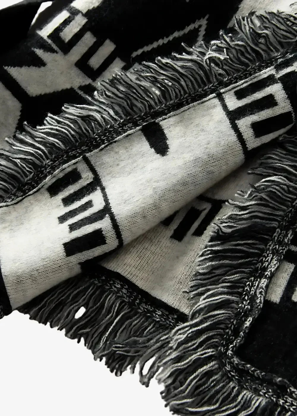 Close-up of the black kimono jacket women's knit, with a black and white geometric pattern and fringed edges