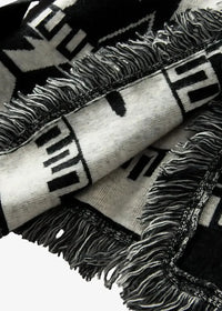 Close-up of the black kimono jacket women's knit, with a black and white geometric pattern and fringed edges