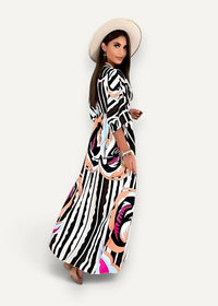 A woman wearing a black kimono maxi dress with bold black and white stripes and pink floral patterns