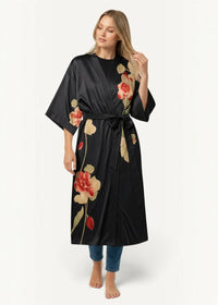 Black satin kimono robe with floral pattern featuring red and beige roses and green leaves tied at the waist