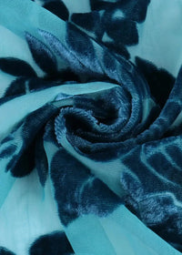 Close-up of the blue kimono jacket fabric, a sheer teal chiffon with a navy velvet floral pattern