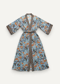 Light blue kimono maxi dress with orange and black floral botanical patterns, matching belt, and decorative edge trim