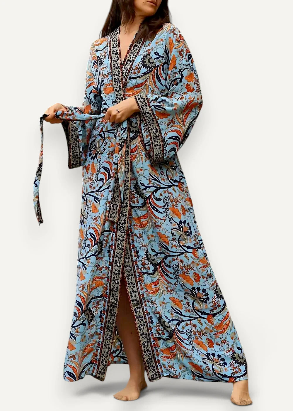 Blue kimono maxi dress with flowing light blue fabric, intricate orange and navy floral patterns, v-neckline, and wide sleeves