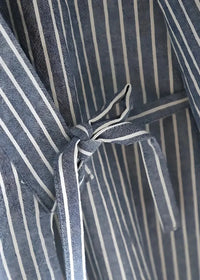 A navy blue and white striped woven fabric tie with knotted end for blue kimono pajamas