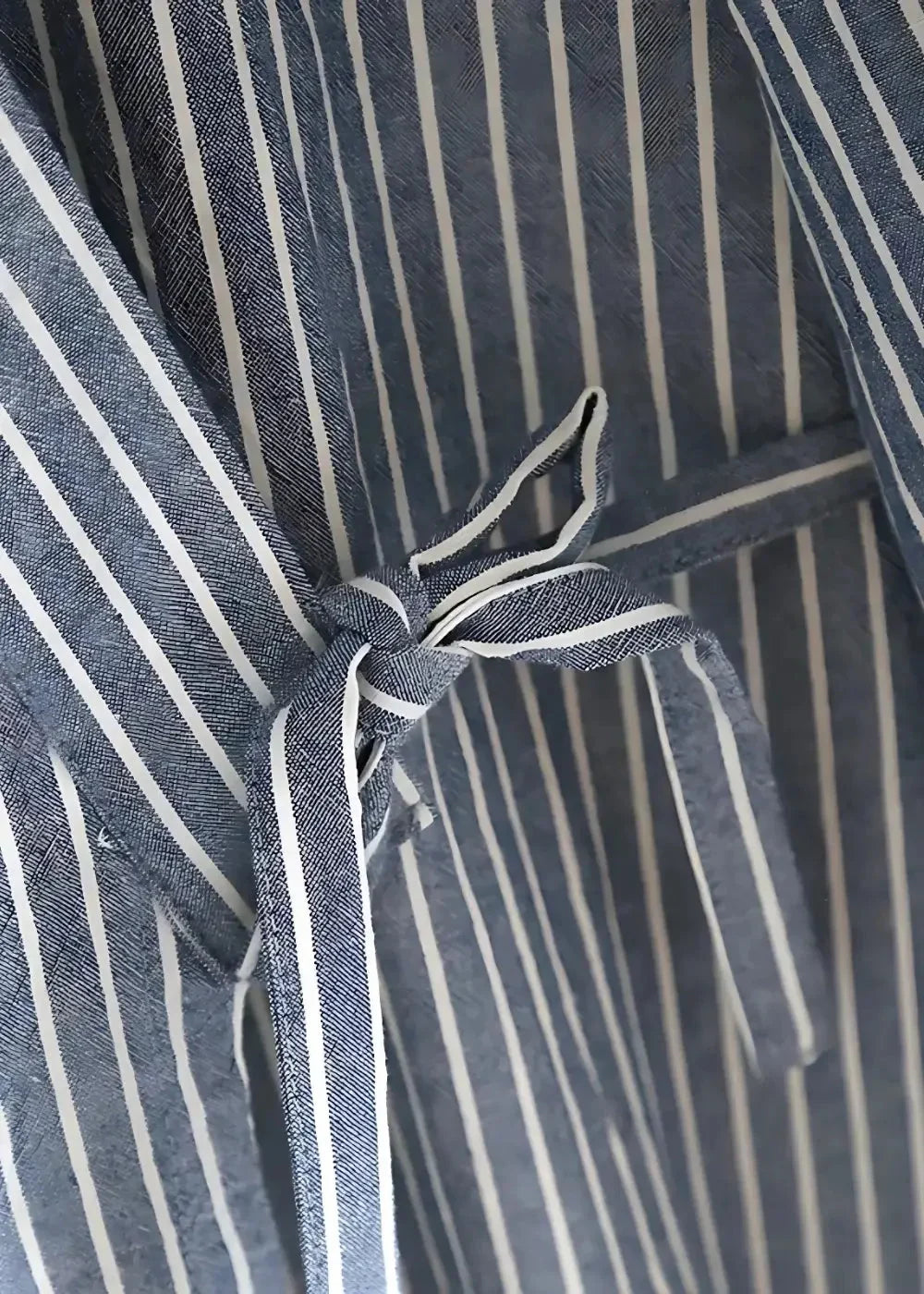 A navy blue and white striped woven fabric tie with knotted end for blue kimono pajamas