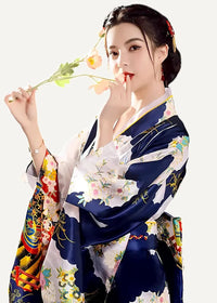 A woman wearing a vibrant deep blue silk yukata with intricate floral and traditional Japanese motifs