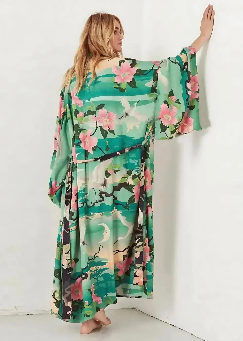 A flowing long-sleeved boho hippie kimono robe in vibrant green with delicate floral and crane pattern