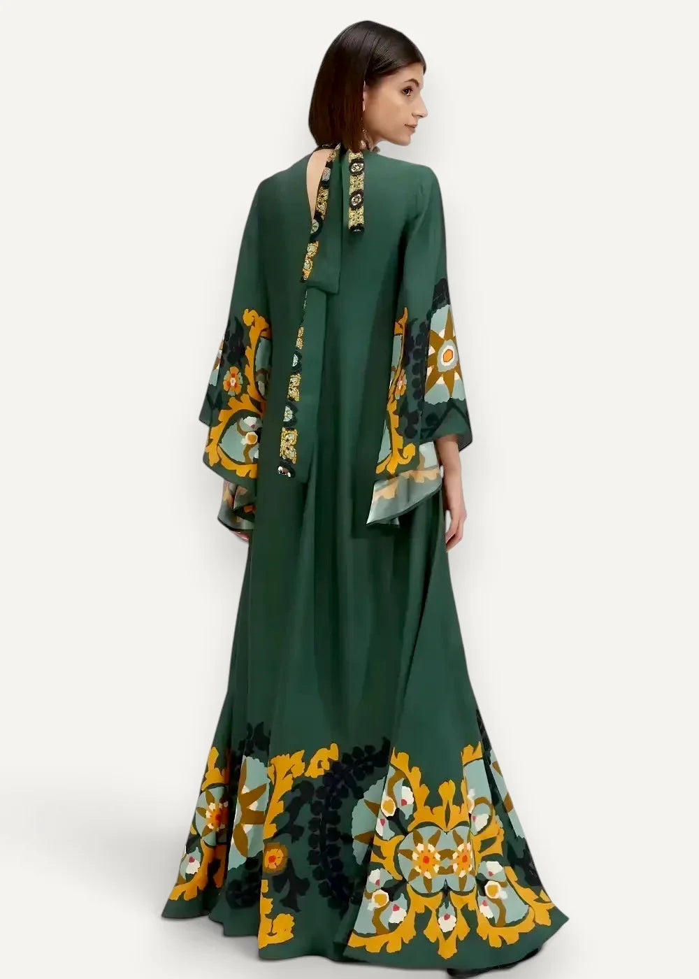 A flowing emerald green boho kimono maxi dress with gold black teal floral paisley patterns bell sleeves and back tie detail