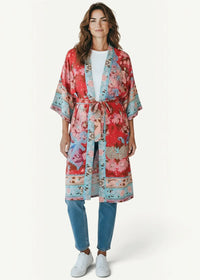 A boho style kimono with vibrant red and blue floral print made of lightweight fabric with a matching belt