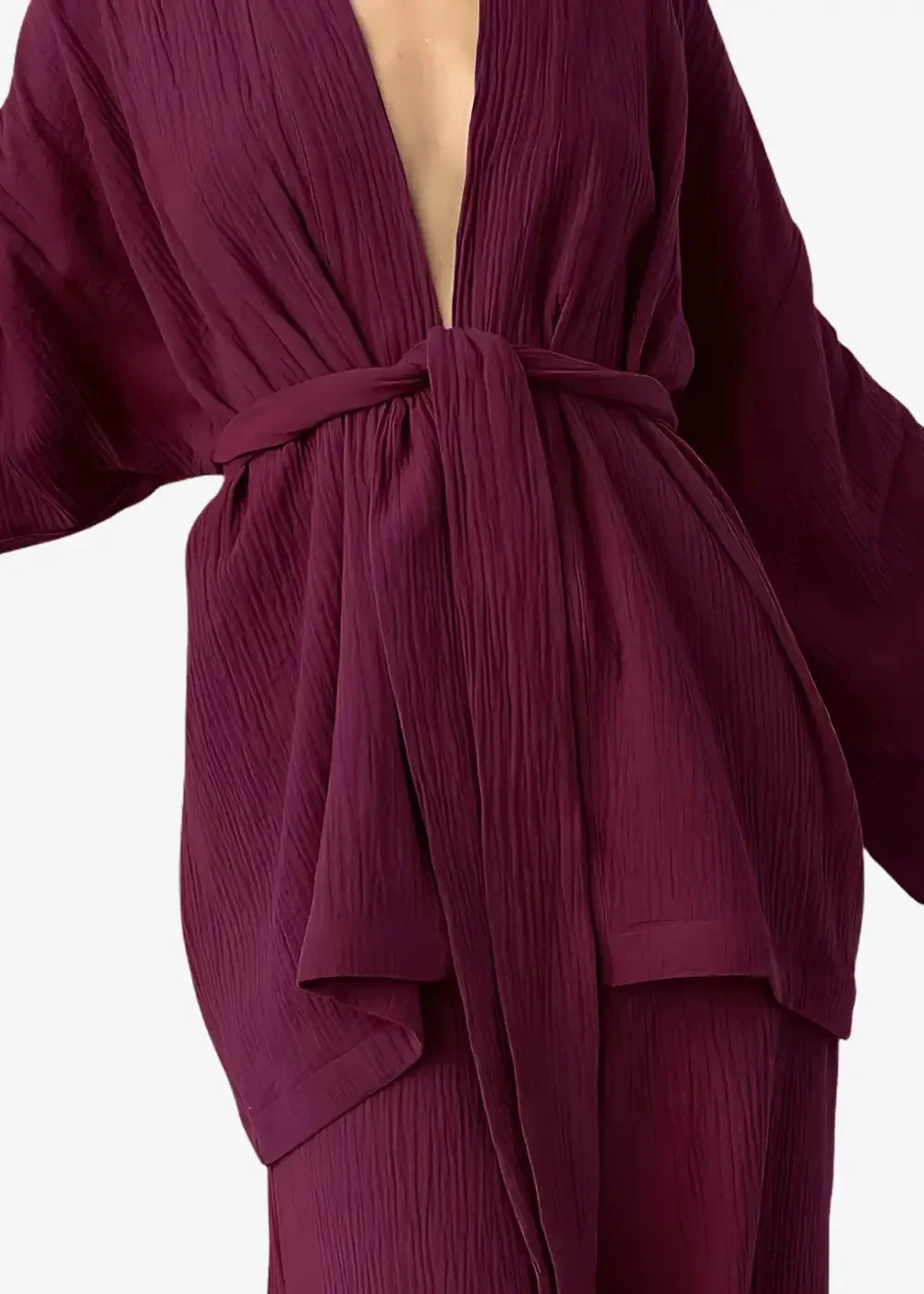 A flowing deep burgundy kimono pajama robe with ribbed texture wide sleeves tied at the waist