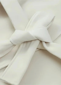 Close-up of the cream casual kimono jacket belt tied in a soft bow