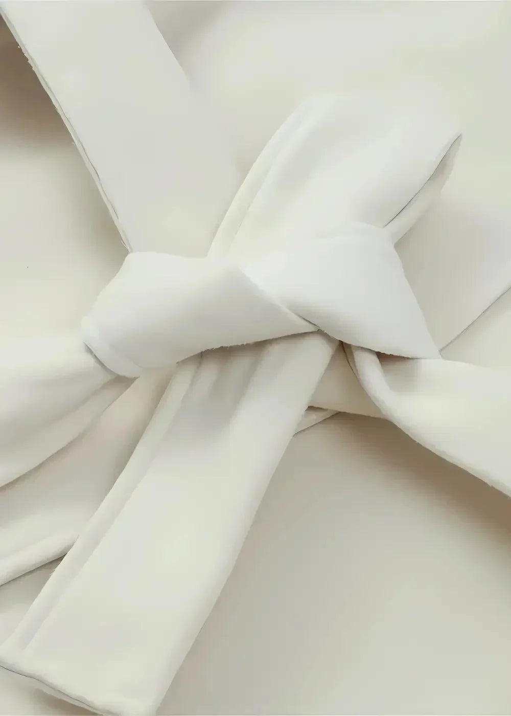 Close-up of the cream casual kimono jacket belt tied in a soft bow
