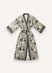 A cream-colored chiffon kimono dress with intricate black floral pattern, v-neckline, three-quarter sleeves, and belt