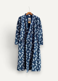 A navy blue cotton men’s kimono robe with a white leaf pattern hanging on a wooden hanger