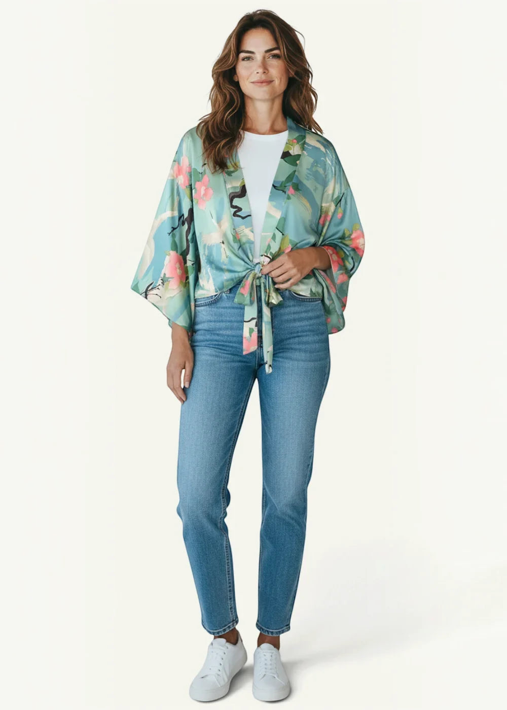 A light teal satin cropped kimono with a vibrant pink and green floral pattern tied at the waist