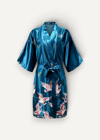 A teal satin silk dressing robe with a vibrant pink and white flying crane pattern tied at the waist with a matching belt
