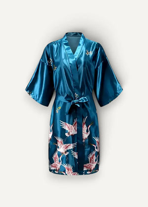 A teal satin silk dressing robe with a vibrant pink and white flying crane pattern tied at the waist with a matching belt