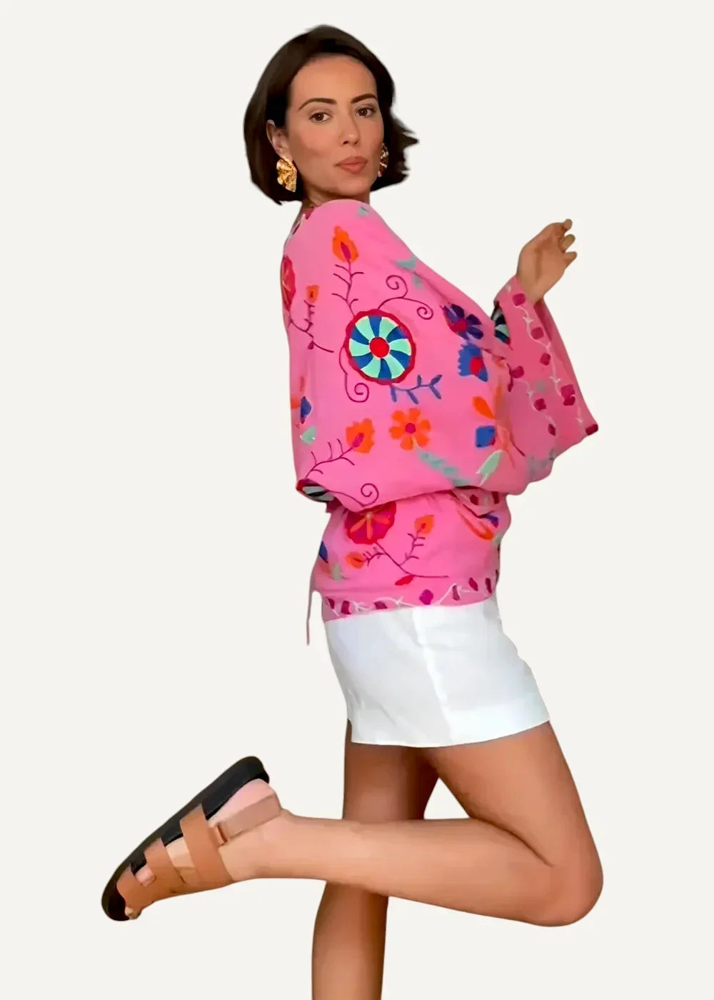 A vibrant pink embroidered kimono jacket with colorful floral and circular patterns on lightweight fabric