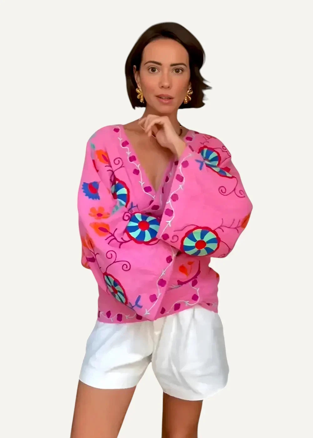 Vibrant pink embroidered kimono jacket with colorful blue orange and purple floral and circular patterns