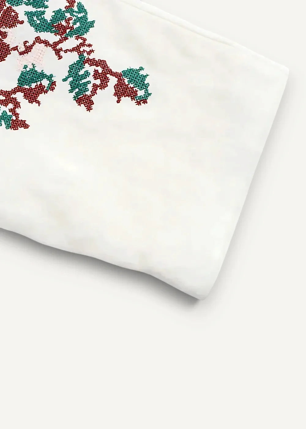 Close-up of the embroidered kimono sleeve, white fabric with red and green tree branch embroidery
