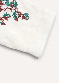 Close-up of the embroidered kimono sleeve, white fabric with red and green tree branch embroidery