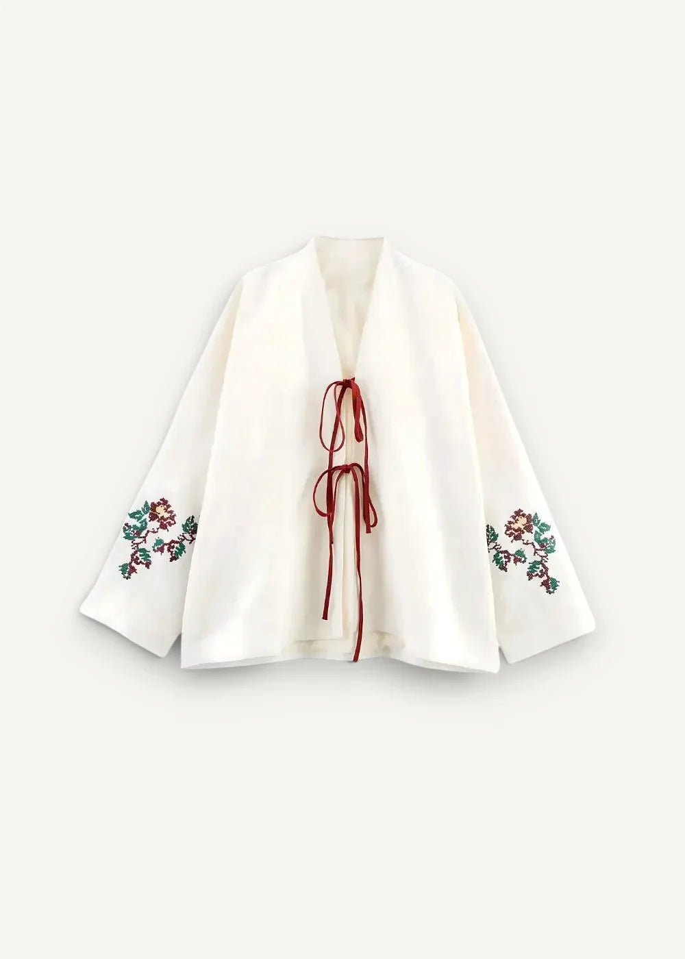 White embroidered kimono jacket with red and green floral sleeve patterns and a matching red front tie
