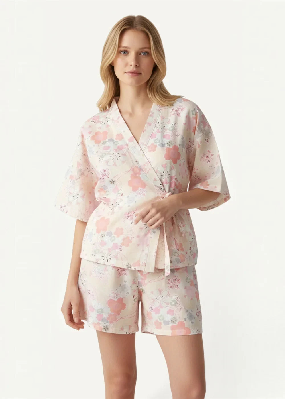 A soft pink floral cotton kimono pajama set with satin finish featuring v-neck robe and tie-side waist with shorts
