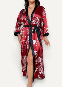 A luxurious long floral kimono robe in red satin with black trim featuring an elegant floral pattern
