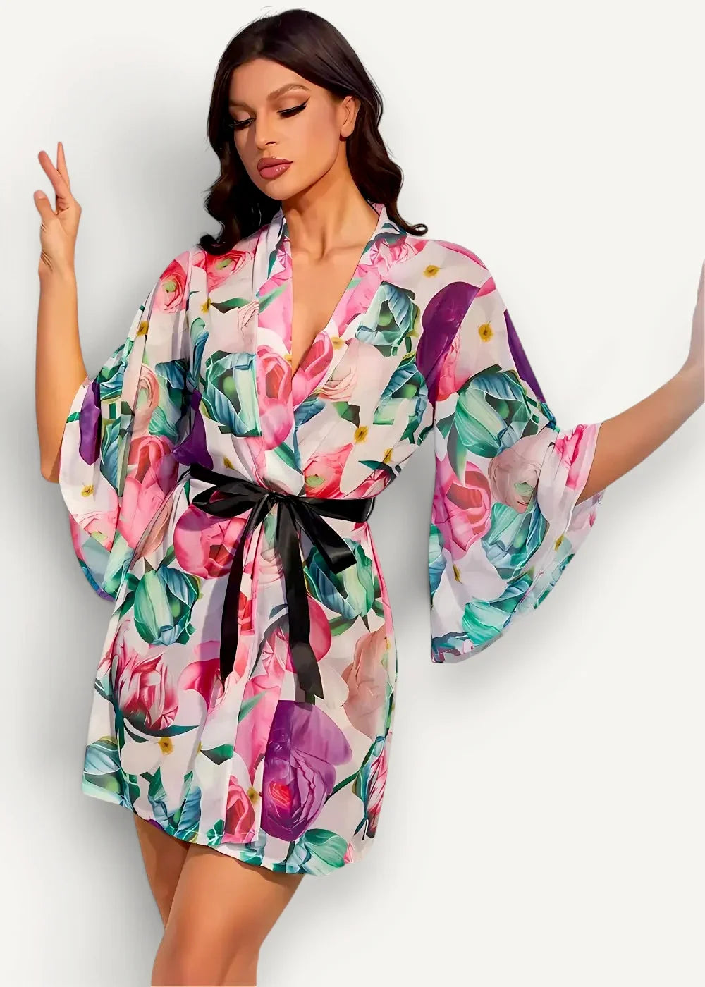 A floral kimono robe with vibrant print wide sleeves and a black satin belt for comfortable lounging