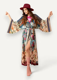 A flowing floral kimono wrap dress with long sleeves, cinched waist, high slit, and pastel pink blue green tones on lightweight fabric