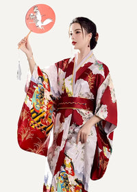 A woman wearing a vibrant red and white formal kimono with intricate traditional Japanese illustrations and flowing sleeves