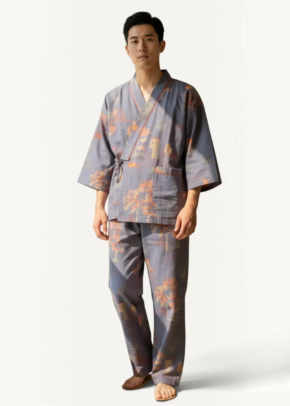 A man wearing gray cotton kimono pajamas with orange floral patterns and matching pants in japanese style