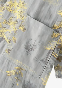 Gray kimono pajamas in fabric with subtle gold and black botanical print and an embroidered pocket detail