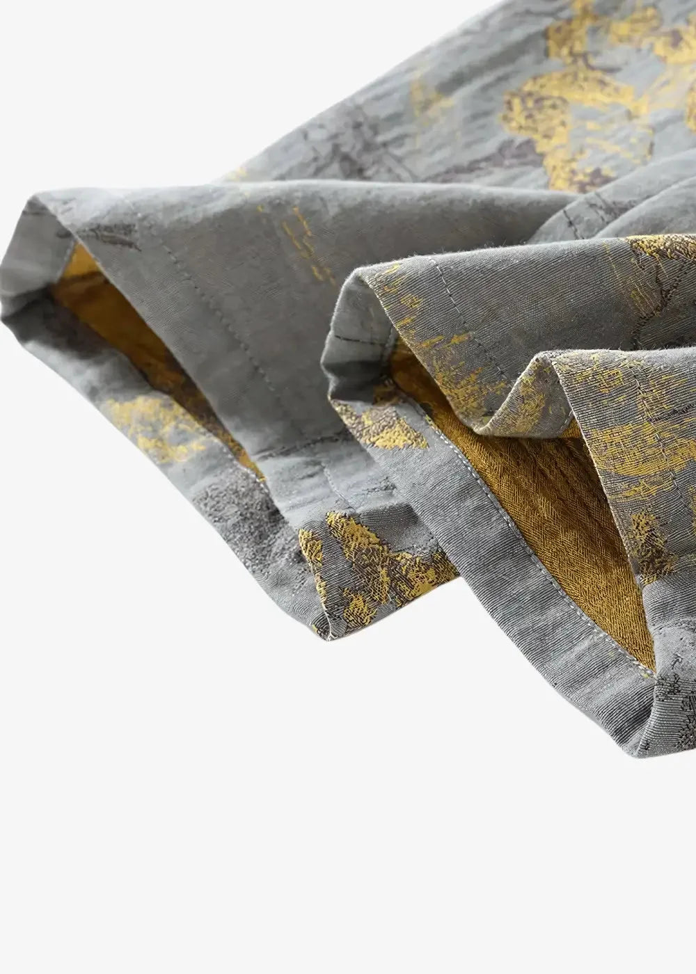 Gray kimono pajamas with subtle gold leaf pattern and visible stitching along the folded hem of gray trousers