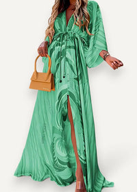 Emerald green kimono maxi dress with bold leafy pattern flowing fabric and a stylish side slit