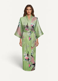 A flowing green silk robe with peacock and pink floral motifs tied at the waist with a matching belt