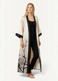 Ivory satin robe featuring flowing long sleeves in soft cream silk with black tree branch patterns and trim