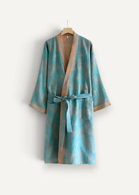 A teal and gold floral-patterned silk Japanese cotton kimono robe with a matching belt hanging on a wooden hanger