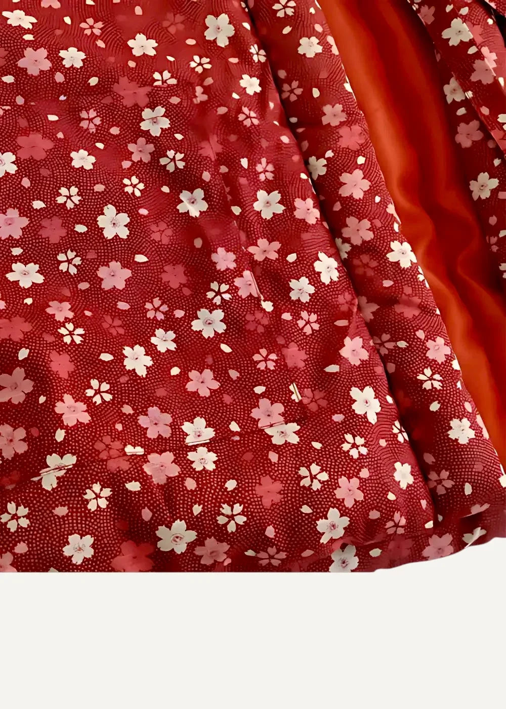 Red fabric with delicate white and soft pink floral pattern and subtle textured weave on japanese haori jacket