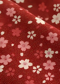 Red fabric of japanese haori jacket with delicate pink and white cherry blossom pattern scattered on the back side