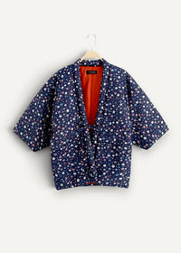 A navy blue quilted Japanese kimono jacket for women with white and light pink floral pattern and orange lining