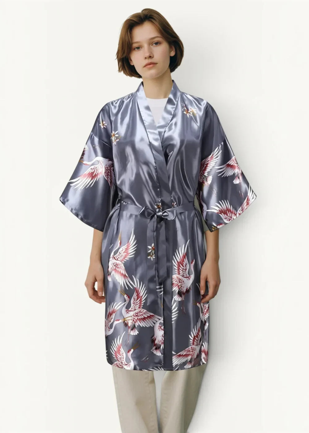 A sleek dark gray satin japanese kimono robe featuring a vibrant pattern of white and pink flying cranes