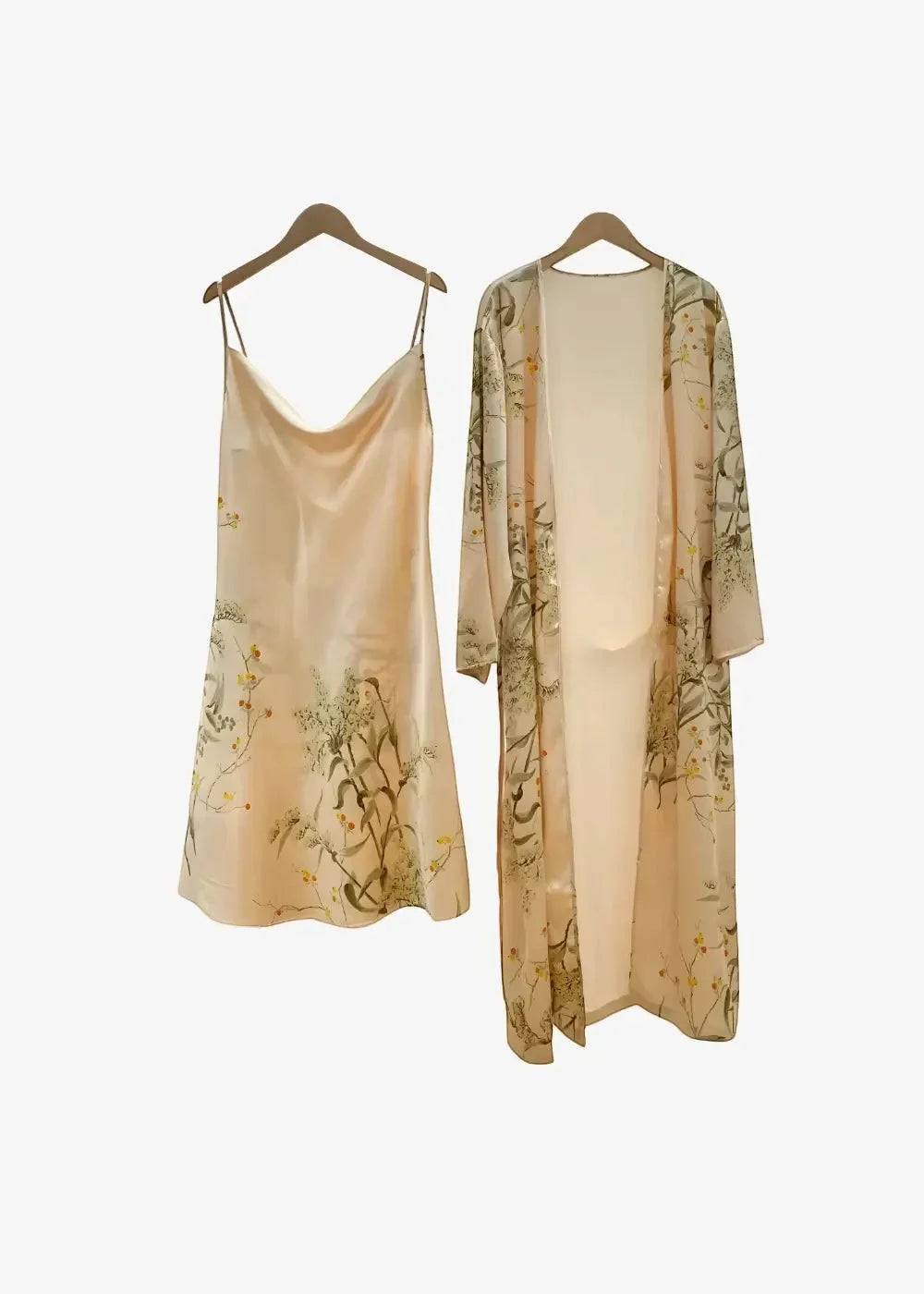 A delicate beige silk Japanese nightgown slip dress with botanical print hangs beside a matching long-sleeved robe