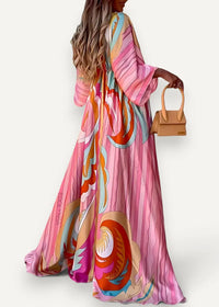A flowing long-sleeved kimono dress beach cover up in vibrant pink with bold orange teal and cream abstract swirls