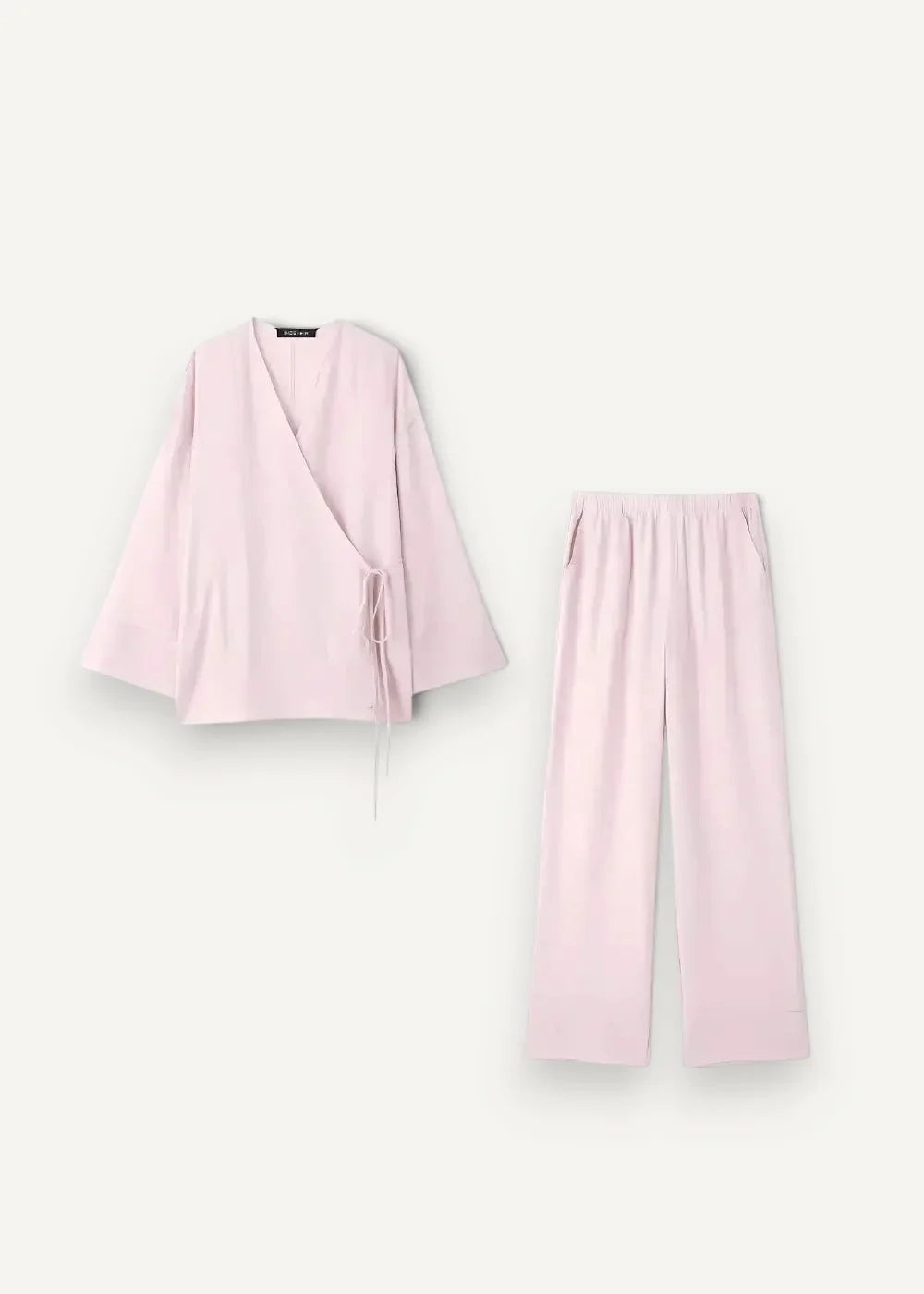 A soft blush pink kimono linen pajama set with a wrap-style top and wide-leg pants made of lightweight cotton