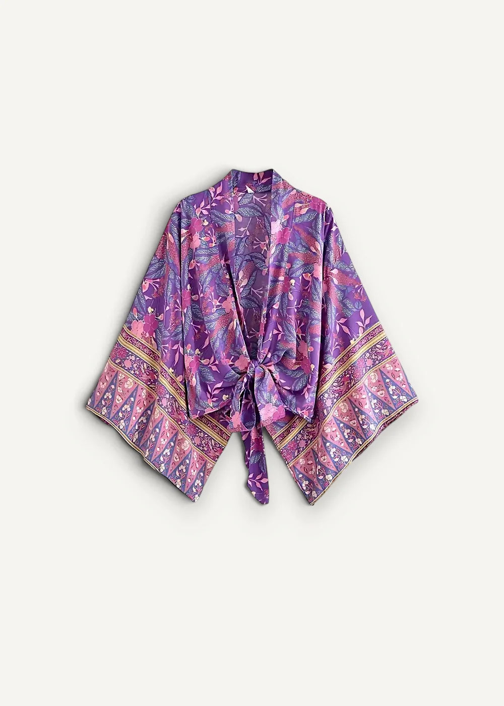 A flowing purple and pink patterned silk kimono with intricate floral designs and gold-trimmed cuffs in a kimono pants set